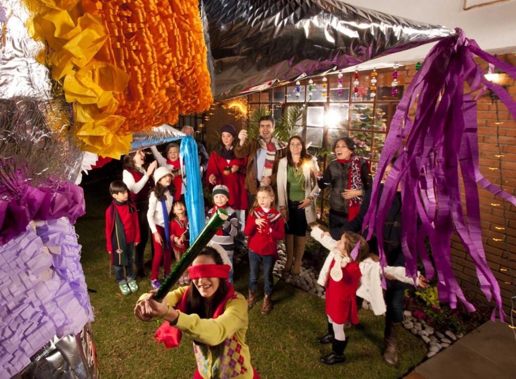 Personas rompiendo piñata en una posada