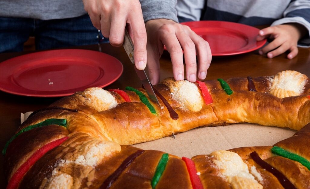 Persona partiendo rosca de reyes